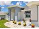 Inviting home entrance with decorative stone landscaping, colorful foliage and grey toned exterior at 10443 Riverside Rd, Port Charlotte, FL 33981