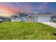 Charming single-story home featuring a well-manicured lawn and a two-car garage at 10443 Riverside Rd, Port Charlotte, FL 33981