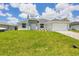 Inviting single-story home features a well-manicured lawn and a two-car garage at 10443 Riverside Rd, Port Charlotte, FL 33981