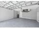 Spacious three-car garage featuring a sealed floor, high ceilings, and modern garage door mechanism at 10443 Riverside Rd, Port Charlotte, FL 33981
