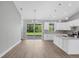 Bright eat-in kitchen featuring white cabinets, an island, stainless appliances, and sliding glass doors to the yard at 10443 Riverside Rd, Port Charlotte, FL 33981