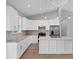 Open kitchen with white cabinets, island, granite counters, and stainless steel appliances at 10443 Riverside Rd, Port Charlotte, FL 33981