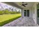 A covered patio with a ceiling fan looks out onto the lush, green backyard at 10443 Riverside Rd, Port Charlotte, FL 33981