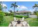 Charming backyard featuring a fire pit with seating, a lush lawn, and a glimpse of the house in the background at 1051 Indian Beach Dr, Sarasota, FL 34234