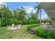 Spacious backyard with a patio, seating area around a fire pit, and lush tropical landscaping for ultimate outdoor enjoyment at 1051 Indian Beach Dr, Sarasota, FL 34234