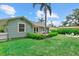 Expansive backyard featuring lush green lawn, patio area, fire pit, and charming exterior view of the home at 1051 Indian Beach Dr, Sarasota, FL 34234