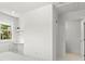 White bedroom with a built-in desk, closet, and view of plants through the window at 1051 Indian Beach Dr, Sarasota, FL 34234