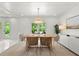 Bright dining room featuring modern decor, stylish seating, and views of the lush outdoors at 1051 Indian Beach Dr, Sarasota, FL 34234