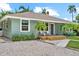 Charming single-story home showcasing a cozy front porch, gravel driveway, and well-maintained landscaping at 1051 Indian Beach Dr, Sarasota, FL 34234