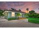 Charming single-story home featuring a cozy front porch, lush lawn, and beautiful landscaping at 1051 Indian Beach Dr, Sarasota, FL 34234