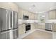 Bright kitchen features stainless steel appliances, cream-colored cabinetry, and white subway tile backsplash at 1051 Indian Beach Dr, Sarasota, FL 34234