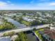 Scenic aerial view of waterfront neighborhood showing canal, bridge, and lush landscaping at 107 Clipper Way # 107, Nokomis, FL 34275