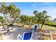 Inviting backyard patio featuring comfortable seating and lush tropical palm trees at 107 Clipper Way # 107, Nokomis, FL 34275