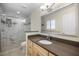 Bathroom featuring marble walk-in shower and neutral wood vanity at 107 Clipper Way # 107, Nokomis, FL 34275