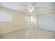 Bright, neutral bedroom with tile flooring, closet and plantation shutters at 107 Clipper Way # 107, Nokomis, FL 34275