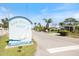 Welcome to Fair Winds Village, featuring a sailboat on the community sign with lush landscaping at 107 Clipper Way # 107, Nokomis, FL 34275