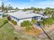 Beautiful exterior view of home surrounded by lush landscaping, palm trees and manicured garden beds at 107 Clipper Way # 107, Nokomis, FL 34275