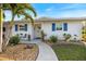 Close up of a house with blue shutters and a sidewalk leading to the front door with decorative accents at 107 Clipper Way # 107, Nokomis, FL 34275