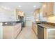 Spacious kitchen showcasing light wood cabinets, stainless steel appliances, and granite countertops with a breakfast bar at 107 Clipper Way # 107, Nokomis, FL 34275