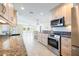 Well-equipped kitchen featuring granite countertops, stainless steel appliances, and ample cabinet space with an open view at 107 Clipper Way # 107, Nokomis, FL 34275