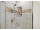 Modern shower with elegant marble-like tile and decorative mosaic accents and fixtures at 107 Clipper Way # 107, Nokomis, FL 34275