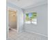 Inviting bedroom featuring neutral walls, tile flooring, a window view of the outdoors, and an ensuite bathroom at 111 66Th Street E Ct, Bradenton, FL 34208