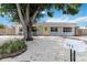 Inviting single-story home featuring a yellow door, mature trees, a neat yard and clean landscaping at 111 66Th Street E Ct, Bradenton, FL 34208