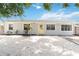 Charming single-story home with a bright yellow door, well-kept landscaping, and a gravel driveway at 111 66Th Street E Ct, Bradenton, FL 34208