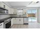 Bright kitchen with stainless steel appliances and a view of the pool through sliding glass doors at 111 66Th Street E Ct, Bradenton, FL 34208