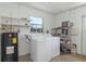 Spacious laundry room with washer, dryer, water heater, utility sink, and ample shelving for storage at 111 66Th Street E Ct, Bradenton, FL 34208