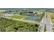 Aerial view highlighting a baseball stadium with ample parking, green spaces, and a scenic pond in the community at 11327 Burgundy Dr, Venice, FL 34293