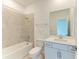 Bathroom with tub and shower combination with tile surround, and vanity with white cabinets at 11327 Burgundy Dr, Venice, FL 34293