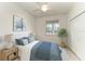 Comfortable bedroom featuring a ceiling fan, natural light from a window, and a spacious closet at 11327 Burgundy Dr, Venice, FL 34293