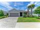 The home features a manicured lawn, stone accents, a paved driveway, and a two-car garage at 11327 Burgundy Dr, Venice, FL 34293