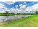 Scenic lake view with lush green shoreline and serene water, reflecting the sky and trees at 11327 Burgundy Dr, Venice, FL 34293