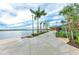 Picturesque waterfront walkway featuring a pier, palm trees, and scenic lake views at 11327 Burgundy Dr, Venice, FL 34293