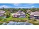 A beautiful backyard view of a screened-in pool and solar panels atop a home, backing up to a pond at 11328 Rivers Bluff Cir, Lakewood Ranch, FL 34202