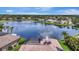 A panoramic aerial view of a serene lakefront community with a home featuring a screened-in pool and solar panels at 11328 Rivers Bluff Cir, Lakewood Ranch, FL 34202