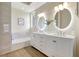 A bright bathroom features double sinks, modern lighting, a tiled tub, and updated fixtures at 11328 Rivers Bluff Cir, Lakewood Ranch, FL 34202