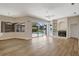 Bright open living room with hardwood floors, a fireplace, and a view of the pool and lake at 11328 Rivers Bluff Cir, Lakewood Ranch, FL 34202