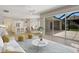 Well furnished living room with hardwood floors, white walls, and a view of the kitchen and outdoor pool area at 11328 Rivers Bluff Cir, Lakewood Ranch, FL 34202