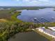 Stunning aerial view showcasing the property's location near a large lake, surrounded by lush greenery and beautiful landscaping at 11508 30Th E Cv, Parrish, FL 34219