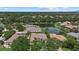 Expansive aerial view of a residential neighborhood showcasing houses surrounding a tranquil lake and lush green trees at 11508 30Th E Cv, Parrish, FL 34219