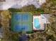 Aerial view of tennis courts and pool surrounded by lush trees at 11508 30Th E Cv, Parrish, FL 34219