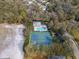 An aerial view showcasing a community pool, tennis courts, and clubhouse nestled among lush greenery at 11508 30Th E Cv, Parrish, FL 34219