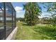 Manicured lawn with tropical plants and a pond with a peek at the pool at 11508 30Th E Cv, Parrish, FL 34219
