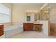 Large bathroom with a soaking tub, walk-in shower, and vanity with excellent lighting at 11508 30Th E Cv, Parrish, FL 34219