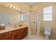 Bright bathroom featuring a glass shower, vanity, toilet and window providing natural light at 11508 30Th E Cv, Parrish, FL 34219