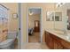 Bright bathroom featuring a vanity with wooden cabinets, a toilet and an adjoining bedroom at 11508 30Th E Cv, Parrish, FL 34219