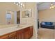Bright bathroom featuring a vanity with wooden cabinets, mirrors and an adjoining bedroom at 11508 30Th E Cv, Parrish, FL 34219